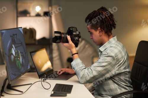 Preview: Young photographer using laptop at his workplace