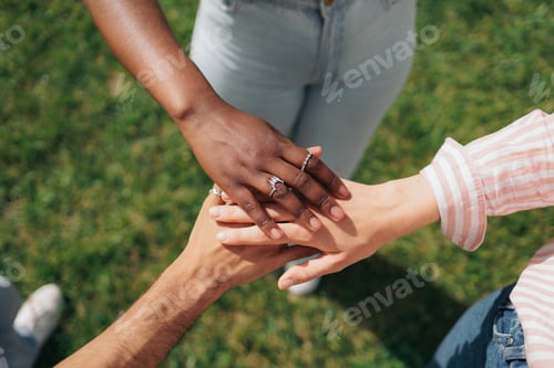 Preview: Multiethnic students putting their hands together. Teamwork, friendship, unity concepts.