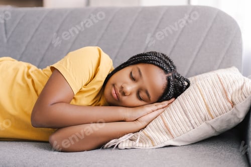 Preview: Young Afrrican American girl sleeping peacefully on comfortable sofa at home