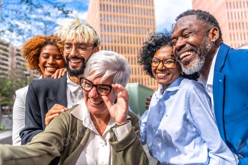 Preview: Mature businesswoman taking a selfie with colleagues outdoors
