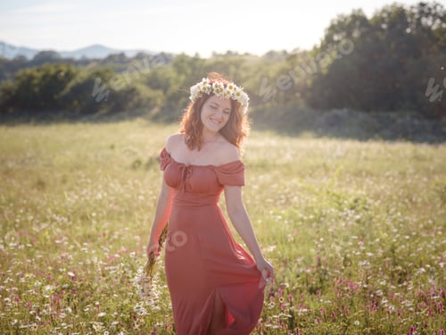 Preview: red-haired woman on a field on a summer evening