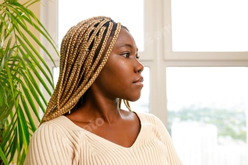Preview: brazilian woman with yellow dreadlocks sitting in living room