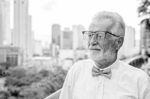 Preview: Handsome bearded senior tourist man exploring the city in black and white