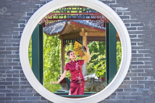 Preview: A Asian girl walks in national clothes with a fan in the park.Chinese woman in a traditional dress