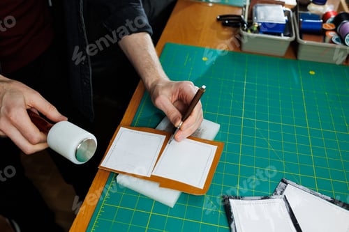Preview: Hands of a professional craftsman make a leather wallet new, clean genuine leather wallet