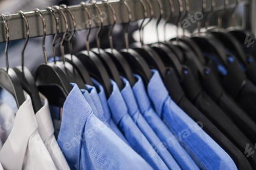 Preview: Men's clothing store, blue and black shirts on the hangers