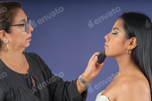 Preview: Makeup artist applying powder to a young woman