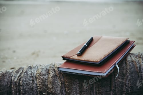 Preview: Notebooks,books and pen on the beach.
