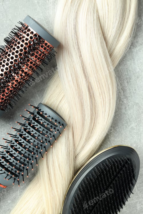Preview: A lock of blonde female hair with hairbrushes