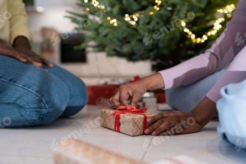 Preview: African couple wrapping xmas presents together, preparing for New Years Eve celebration at home