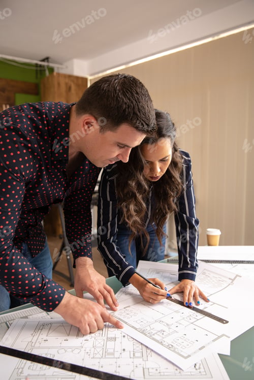 Preview: Team of architects brainstorming ideeas over blueprints