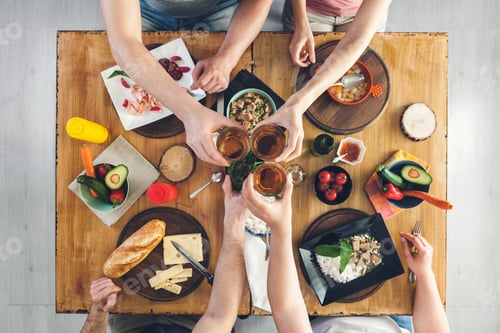 Preview: Top view, Group of people sitting at the table with food, enjoying a drink