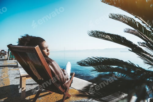 Preview: A girl on a deck chair, quayside