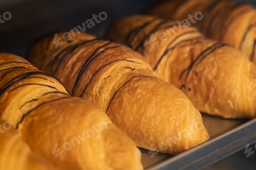 Preview: Close-up, freshly baked croissants in a bakery on a blurred background.