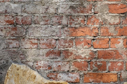 Preview: Fragment of an old red brick wall with traces of plaster.