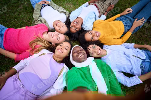 Preview: Selfie of multiracial group young female community friends lying in circle on grass looking smiling.