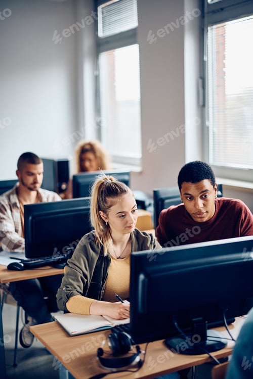 Preview: Young students cooperating while e-learning during computer class at the university.