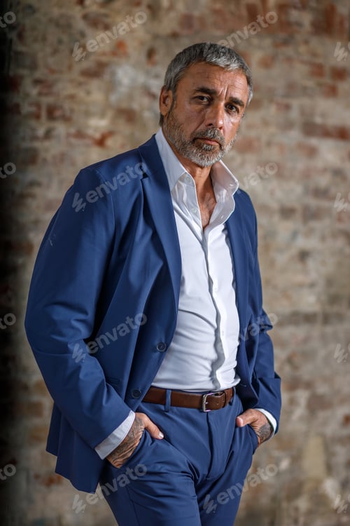Preview: A man in a blue formal suit on a brick background. Portrait of a businessman.