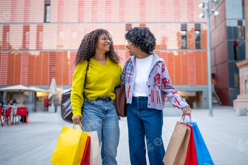 Preview: Two women friends shopping walking city street smiling