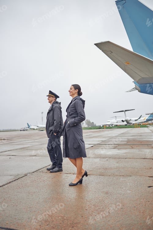 Preview: Portrait of happy confident caucasian airplane crew near plane
