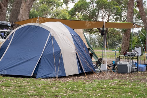 Preview: Family tent setup at campsite. Camping life. Camping table, stove, esky fridge