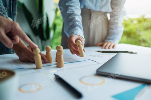 Preview: Business team brainstorming and planning strategy together withwooden people in a meeting