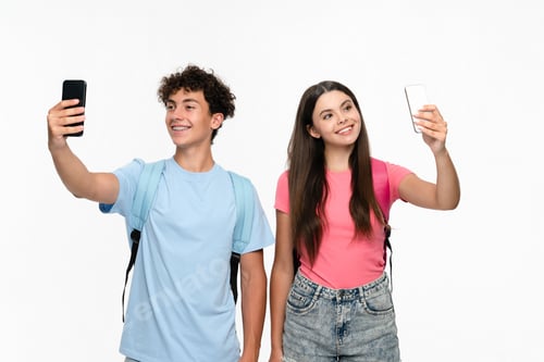Preview: Smiling teenagers in casual with bags takes selfie photo on white background.