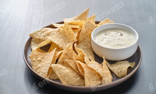 Preview: mexican hot queso blanco cheese dip with corn tortilla chips on plate