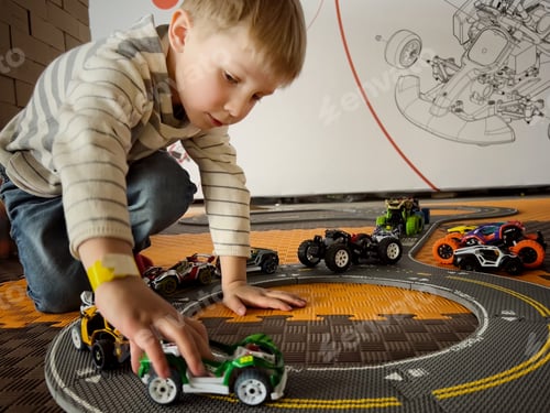 Preview: Cute little caucasian boy playing with toy car track