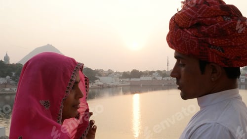 Preview: Closeup of an Indian couple in traditional outfits with River Ganges in the background.