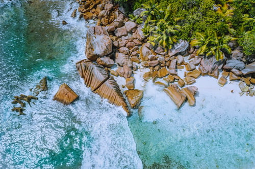 Preview: Anse Cocos beach tropical island La Digue Seychelles. Drone aerial view of foam ocean waves rolling