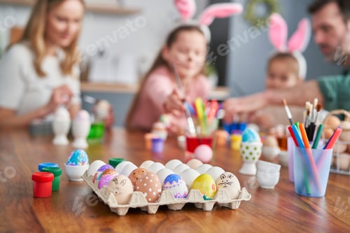 Preview: Colorful easter eggs in the foreground and family in the background