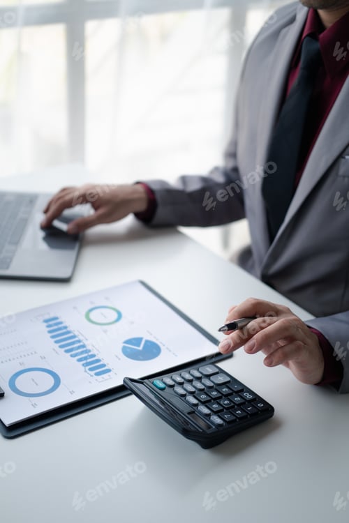 Preview: Close up view of Businessman using a calculator to calculate financial accounts at his office desk.