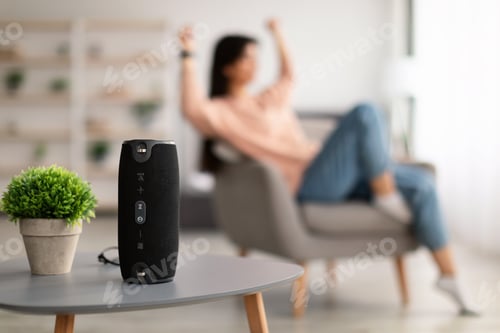 Woman Enjoying Music with Wireless Speaker at Home