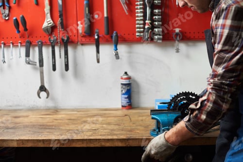 Preview: Male mechanic working in bicycle repair shop using tools