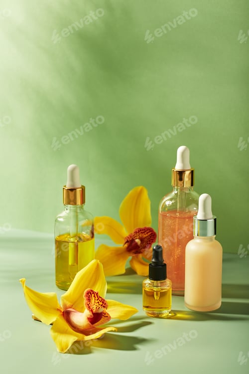 Preview: Cosmetic care products in glass bottles with orchid flowers - serums, cream, gel, oils. Concept for