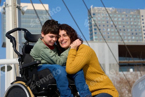 Preview: Happy boy with disability hugging mother outdoors in city - cerebral palsy concept