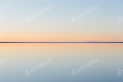 Preview: Horizon where land meets sky, across the flooded surface of Salt Flats at dawn