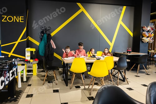 Preview: Four kids eating italian pizza in pizzeria. Children eat at cafe.