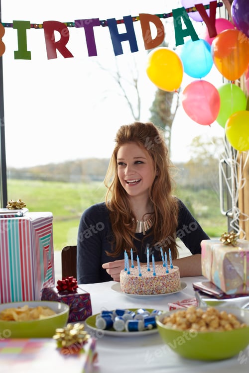 Preview: Teenage girl at table with birthday cake