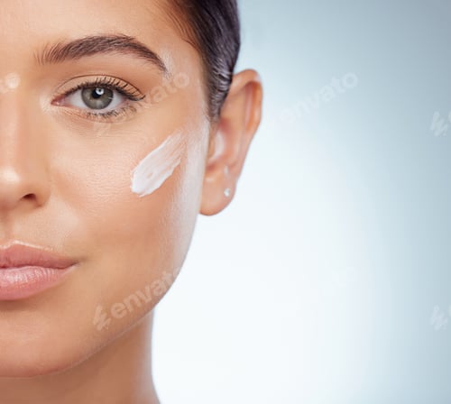 Preview: Closeup portrait beautiful woman with face cream on her cheek posing with copyspace. Caucasian mode