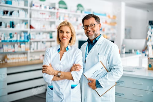 Preview: Portrait of happy pharmacists in drugstore looking at camera.