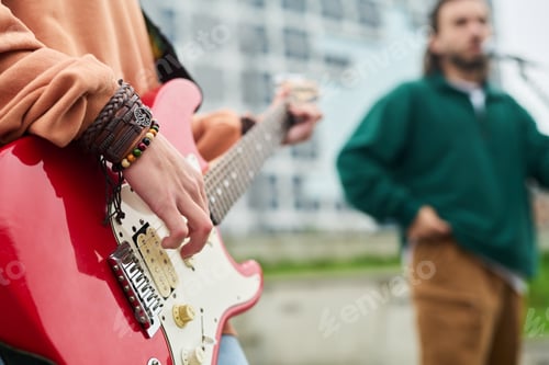 Preview: Young Adult Caucasian Woman Playing Electric Guitar Outdoors during Performance