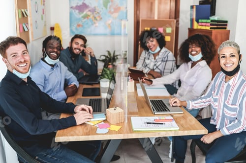 Preview: Multiracial young people working inside modern office while wearing protective masks