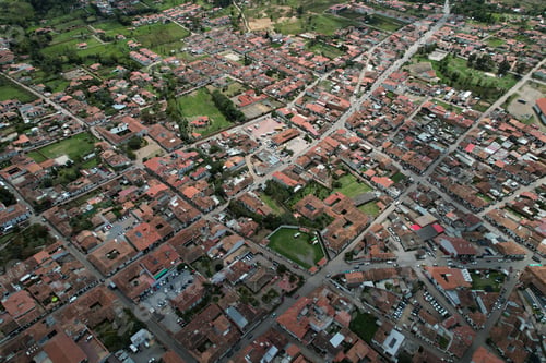 Preview: Aerial shot of a Colombian neighborhood with a group of houses and green field in El Cerrito