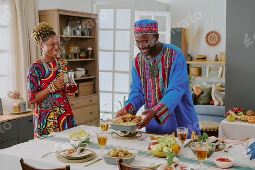 Preview: Middle Aged Black Man Serving Food While Smiling during Kwanzaa Celebration