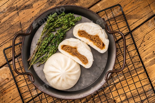Preview: Chinese Bao Baozi steam bun with meat on steel tray. wooden background. top view