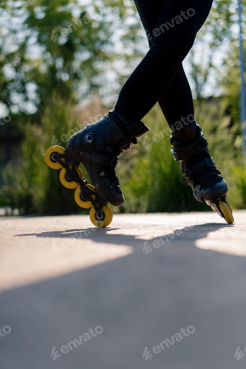 Preview: sporty girl practicing tricks on roller skates in park on city background enjoying roller