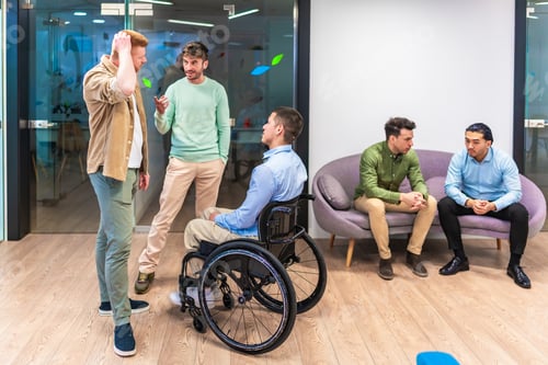 Preview: Managers discussing business strategy with disabled colleague in wheelchair in modern office