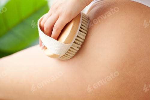 Preview: Woman scrubbing her legs with a brush making skin peeling in the bathroom